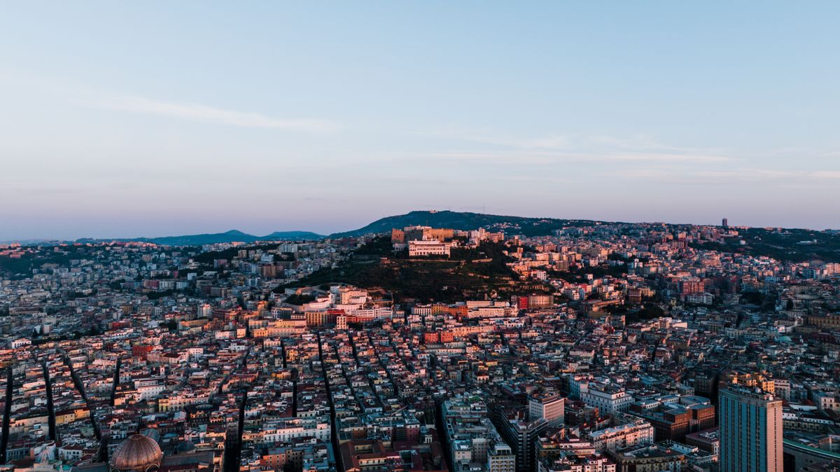 Aerial view of Naples at dusk with Castel Sant'Elmo on the hilltop, Campania, Italy