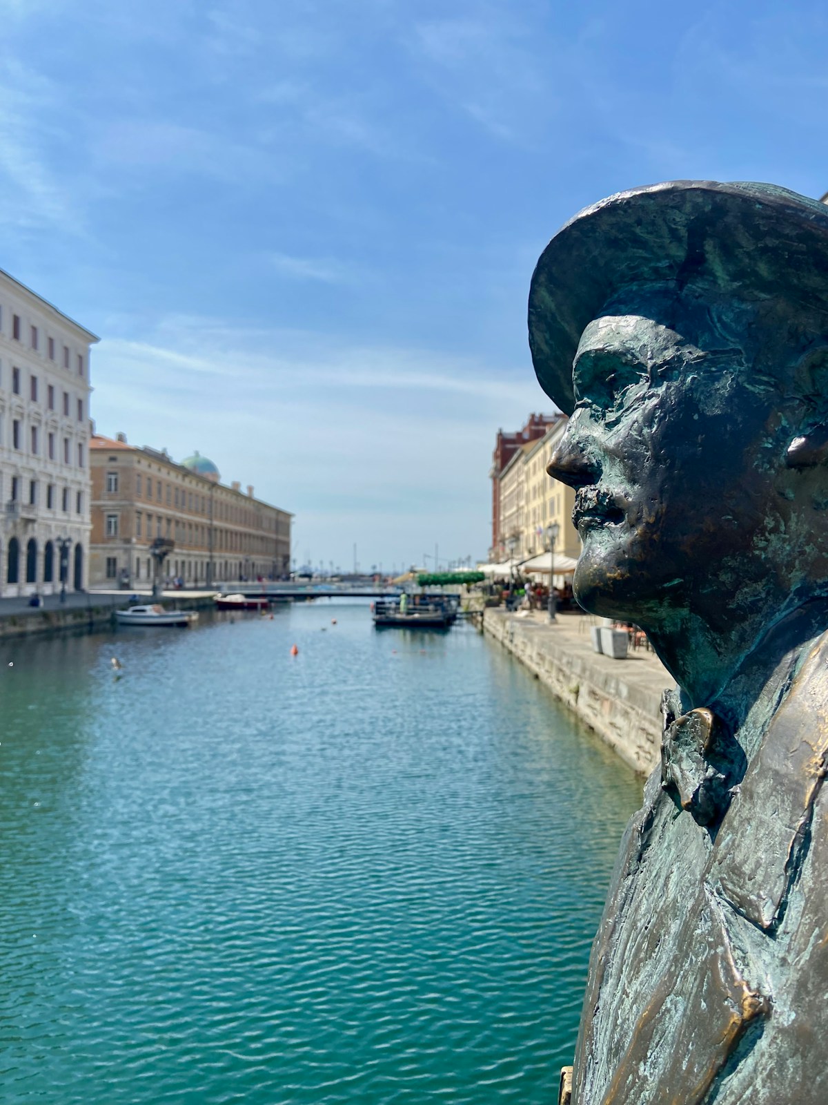 Statue by a river with buildings, Trieste, Friuli-Venezia Giulia, Italy