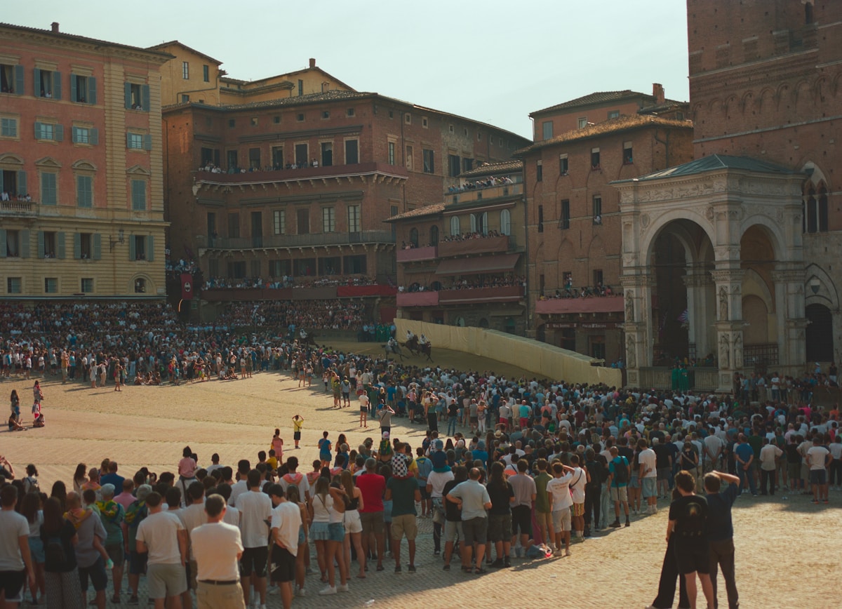 Crowd gathered in a large historic Italian piazza, Siena, Tuscany, Italy