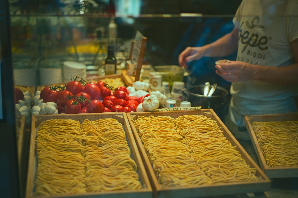 Fresh pasta, tomatoes and garlic displayed for sale, Venetian food Italy