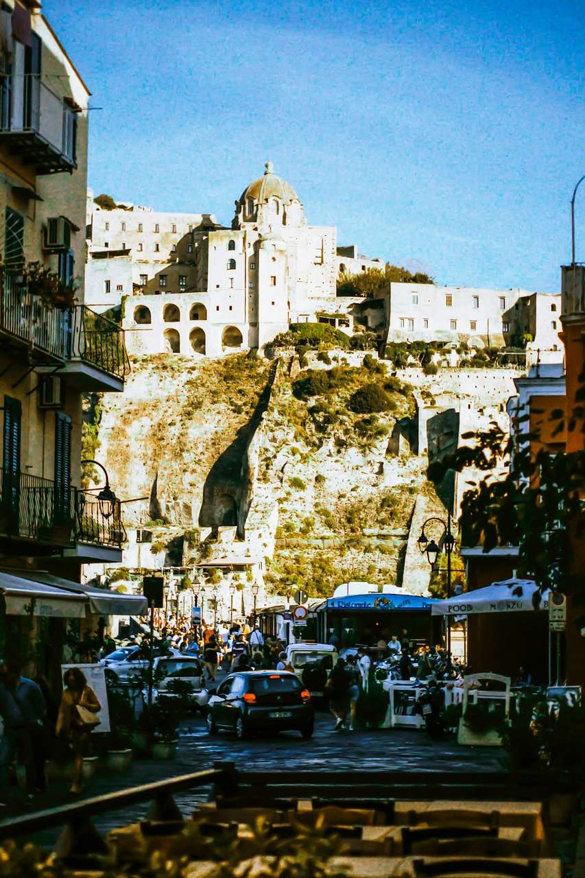 Busy street leading towards a church and castle on a cliff in Ischia Porto, Bay of Naples, Campania, Italy
